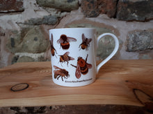 Load image into Gallery viewer, Bee mug by Alice Draws The Line. A china tea or coffee cup covered in bee illustrations